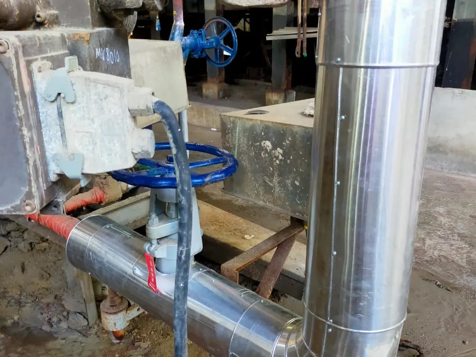 Clad vertical pipe and insulated line at a valve