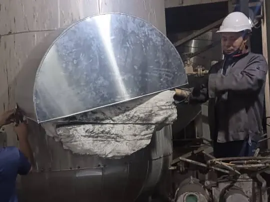 Technician fitting cladding over an insulated vessel head