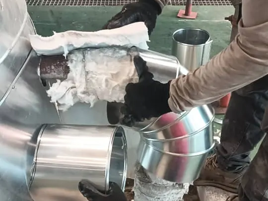 Fitting insulation and cladding segments on a pipe elbow